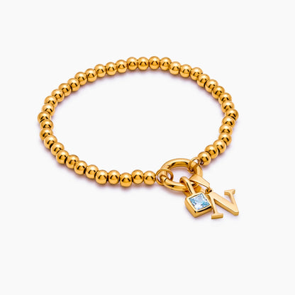 Beaded initial birthstone bracelet flat lay — Olivia Jewelry