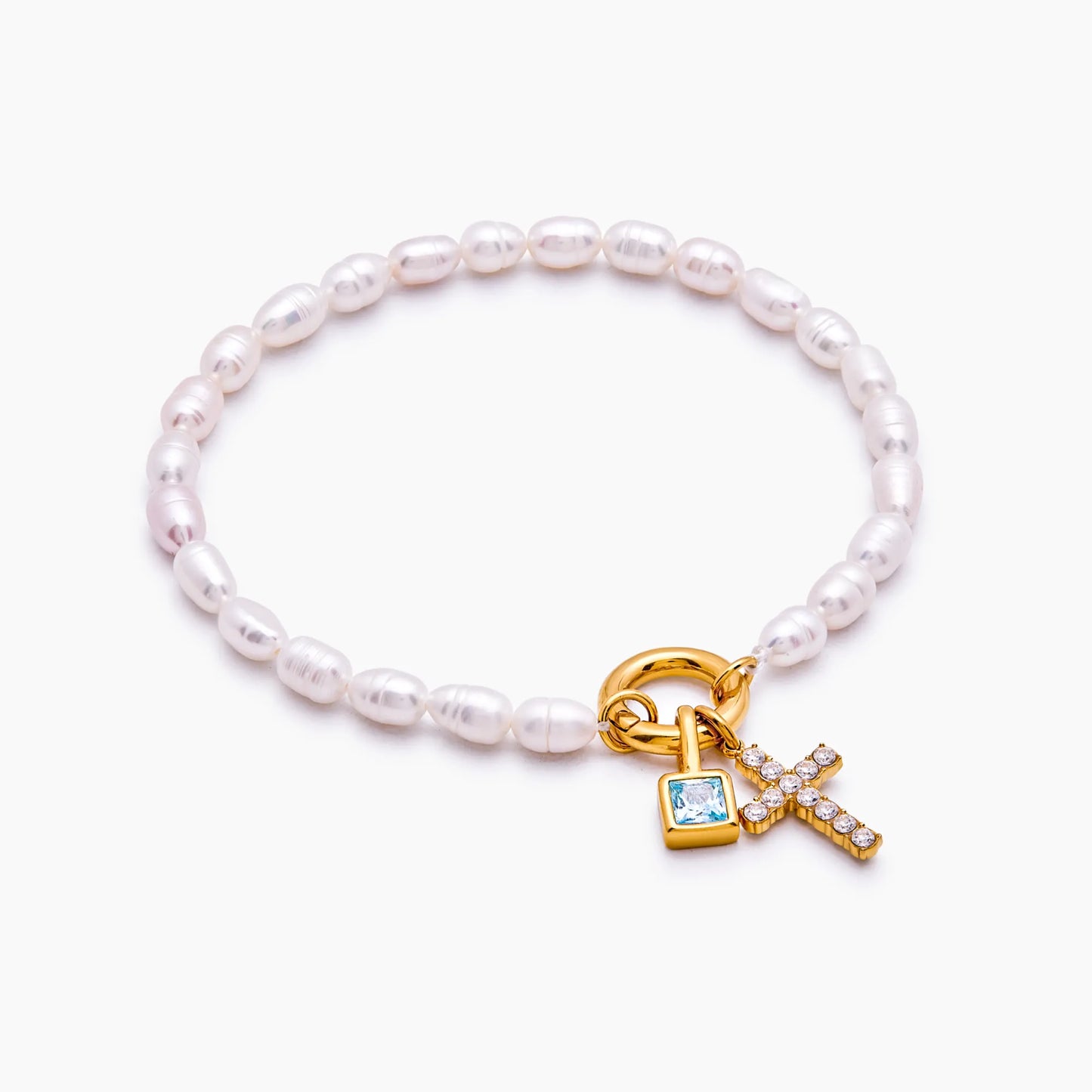 Gold pearl cross charm bracelet worn on wrist — Olivia Jewelry