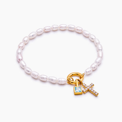 Gold pearl cross charm bracelet worn on wrist — Olivia Jewelry